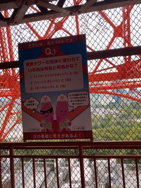 A quiz sign along Tokyo Tower's outdoor staircase featuring the tower's Noppon mascot characters, marking the climb's height at 40 meters.